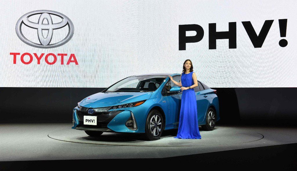 Japanese actress Satomi Ishihara poses beside a redesigned Toyota Motor Prius PHV (plug-in...