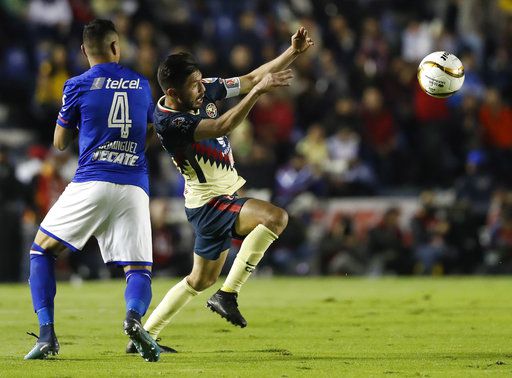 Oribe Peralta, del América, controla un balón junto a Julio César Domínguez, del Cruz Azul,...
