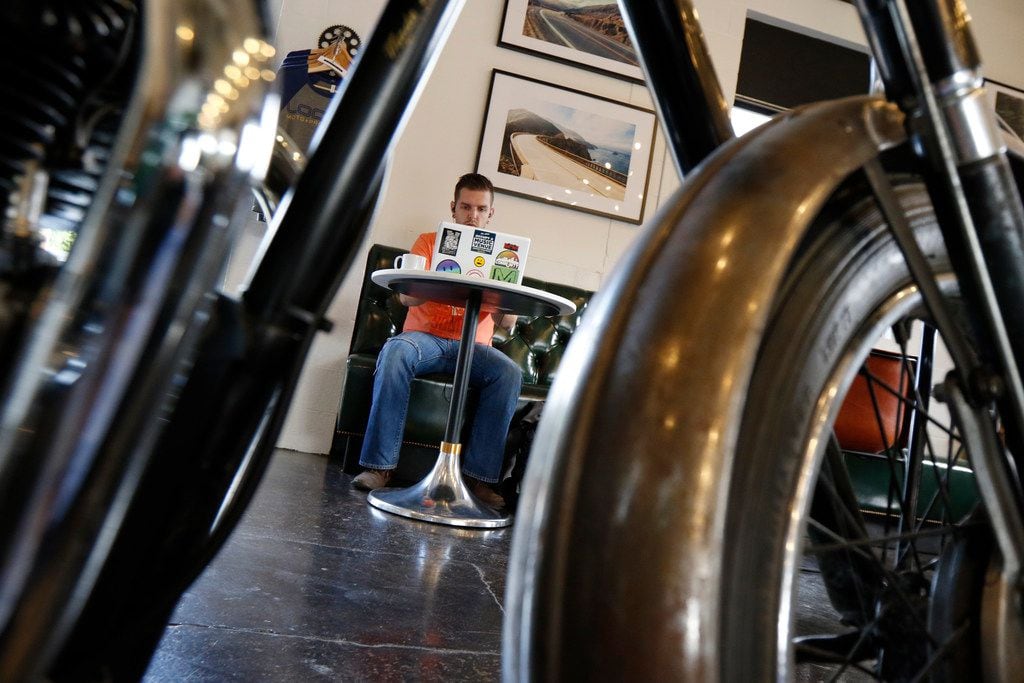Josh Cogan of Dallas relaxes at Local Moto + Provisions, a vintage motorcycle repair shop...