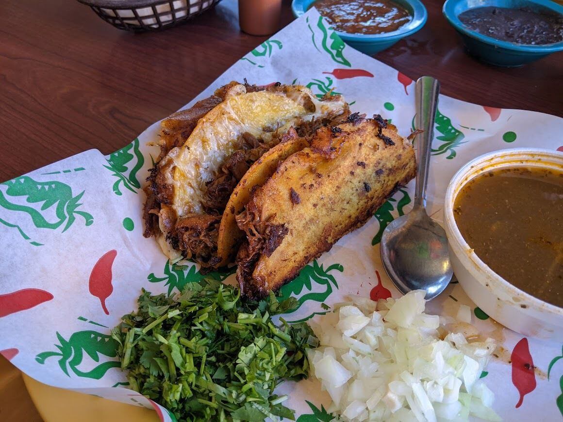 Crispy birria tacos at Don Jorge's on Buckner Boulevard, served with a cup of broth for dipping.