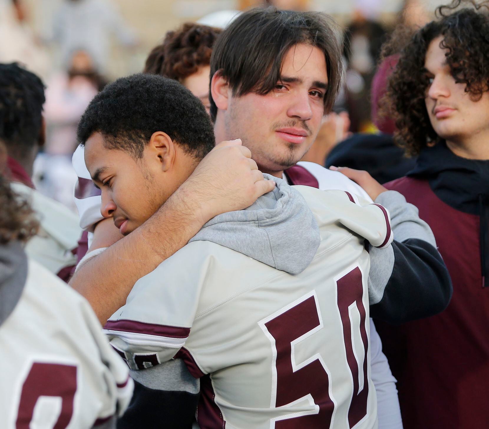 Lewisville High School middle linebacker Michael Canterbury (50) embraces Lewisville High...