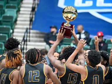 Faith Family players celebrate with the championship trophy after the Blue championship game of the Dallas Mavericks Fall Classic between Faith Family Academy and John Paul II, Tuesday, Nov. 23, 2021, in Frisco, Texas.