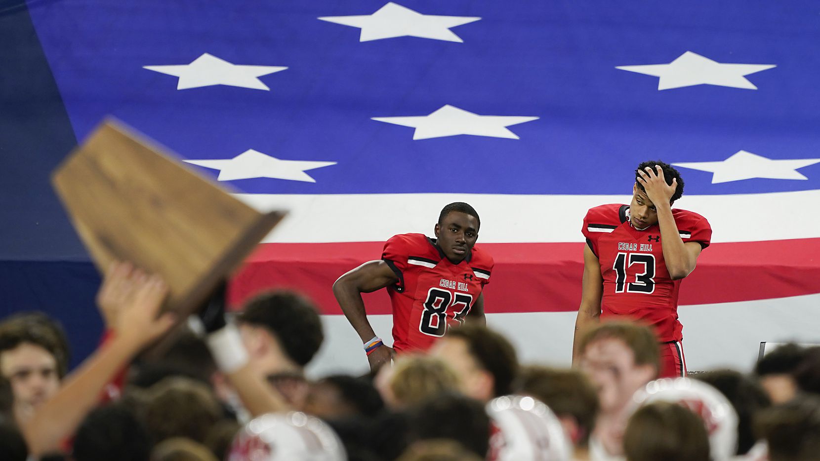 Cedar Hill wide receivers Javien Clemmer (13) and  Felton Brisco (83) watch from the bench as Katy players celebrate with the championship trophy after winning the Class 6A Division II state football championship game at AT&T Stadium on Saturday, Jan. 16, 2021, in Arlington, Texas. Katy won the game 51-14.