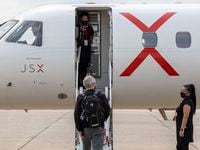 JSX Dallas supervisor Joyce Manalo greets a passenger as he boards at Dallas Love Field’s...