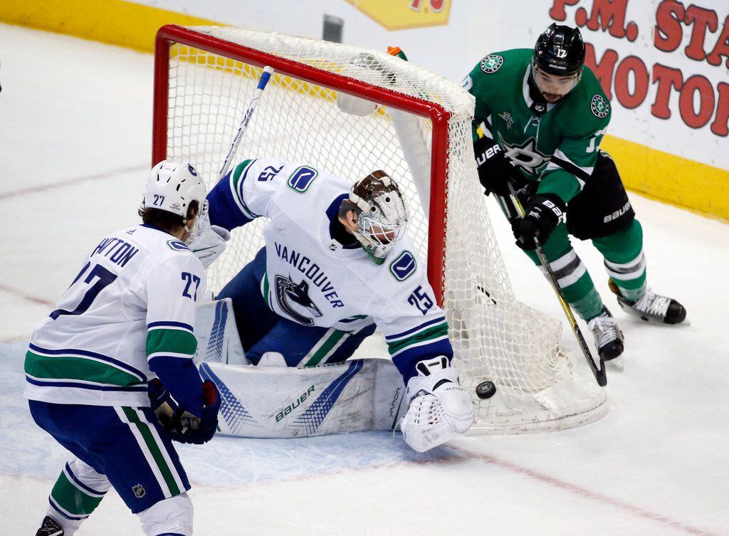 Vancouver Canucks goaltender Jacob Markstrom (25) gets to the puck before Dallas Stars...