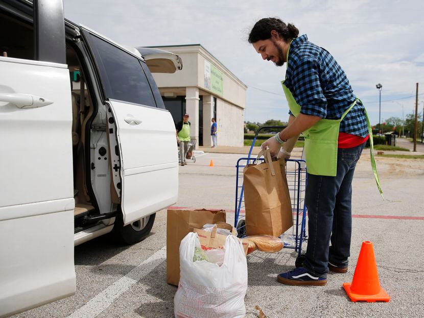 Rev. Juan Rios unloaded  groceries for people curbside outside of the New Room community...