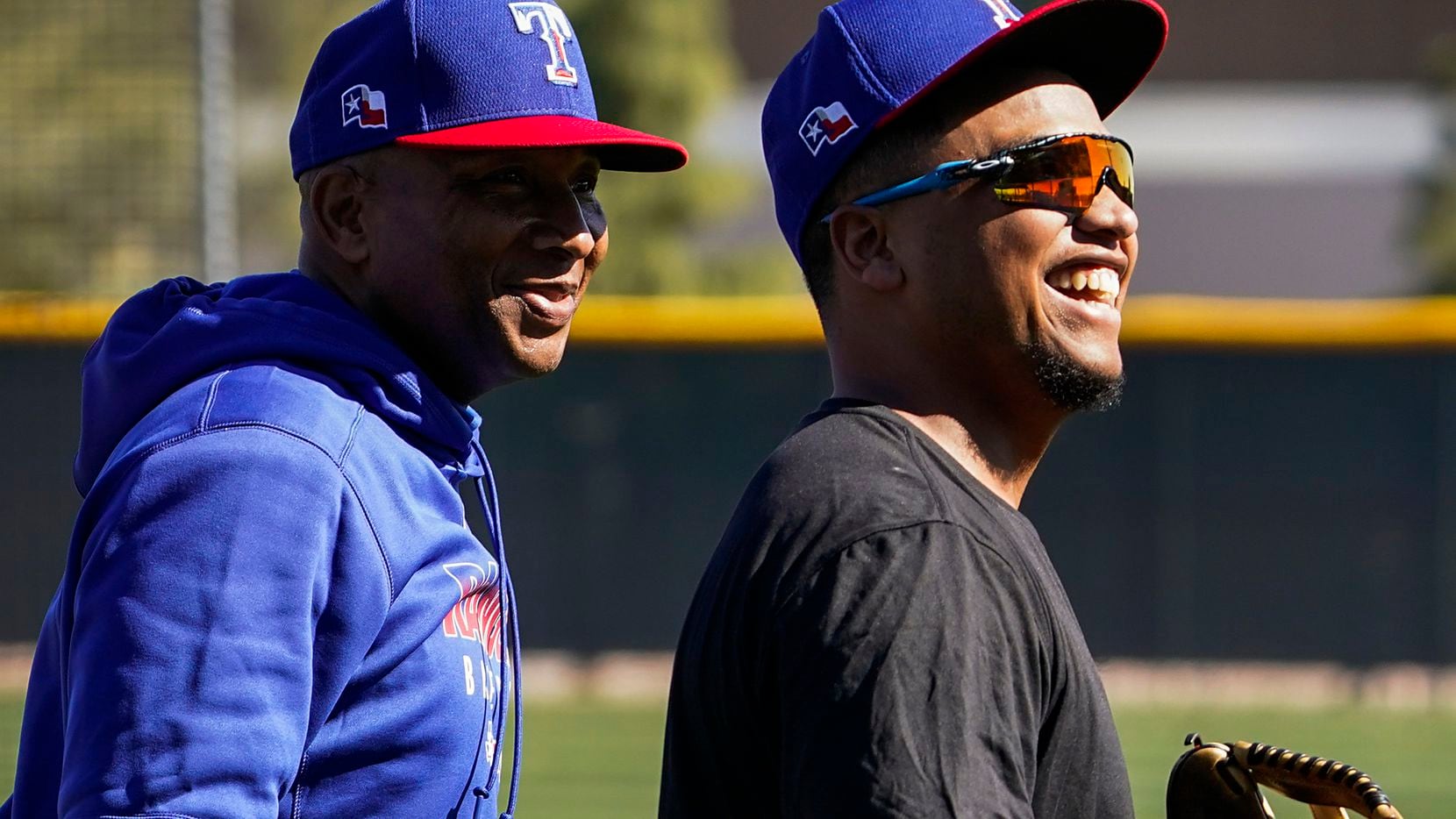 Texas Rangers outfielder Willie Calhoun (right) laughs with third base coach Tony Beasley...