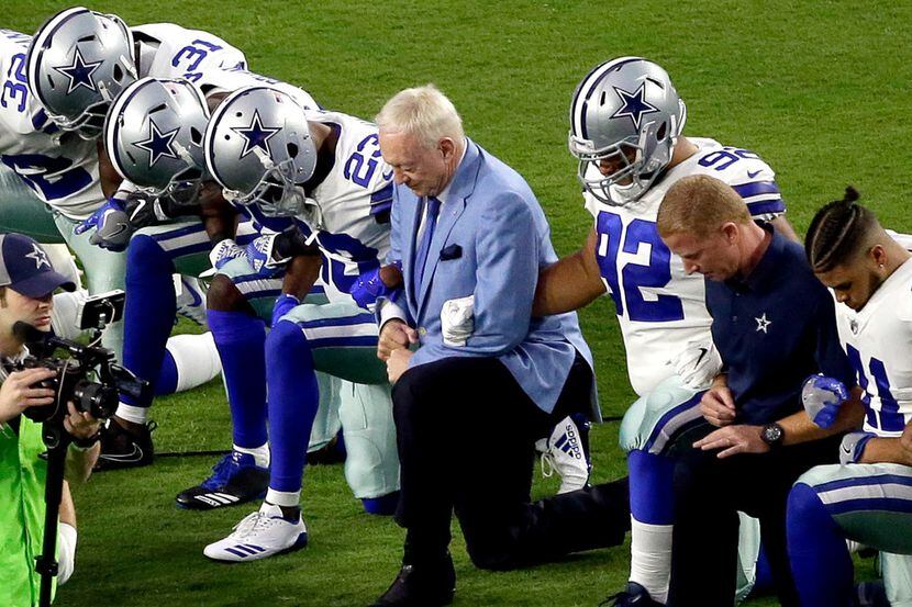 The Dallas Cowboys, led by owner Jerry Jones, take a knee before the national anthem at last...