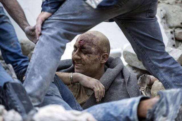 Un hombre herido es rescatado de los escombros en Amatrice, en el centro de Italia, tras el...