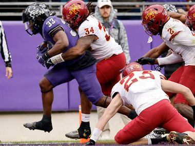 TCU Horned Frogs running back Kendre Miller (33) carries several Iowa State Cyclones...