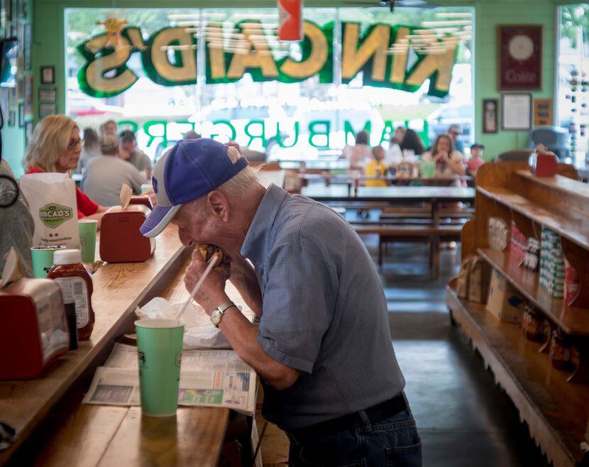 A patron chows down on a burger at Kincaid's on Camp Bowie in Fort Worth.