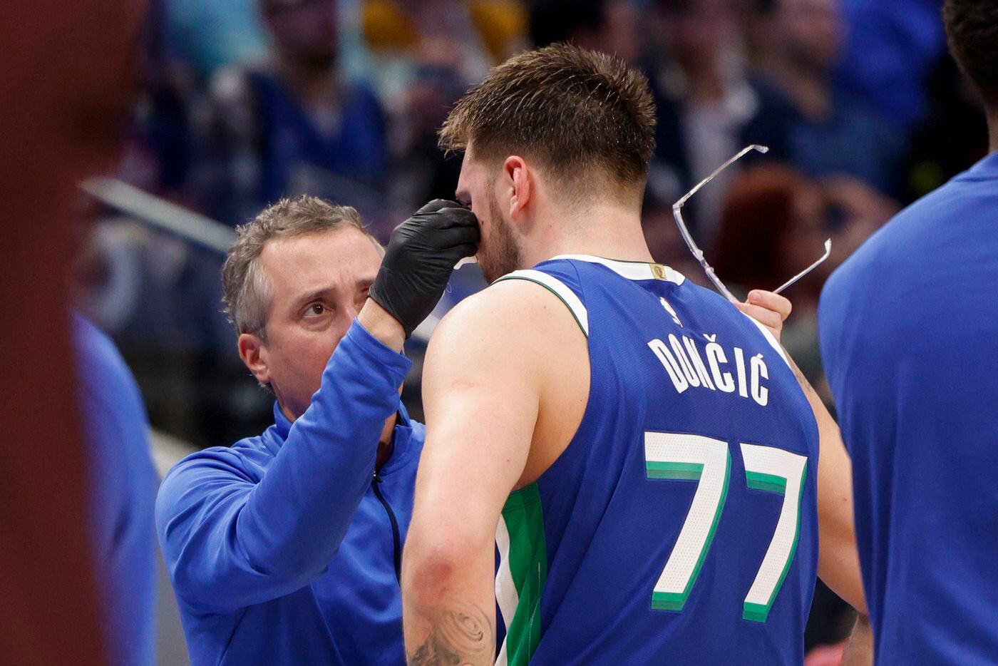 Dallas Mavericks guard Luka Doncic (77) has a cut below his eye treated during the second...