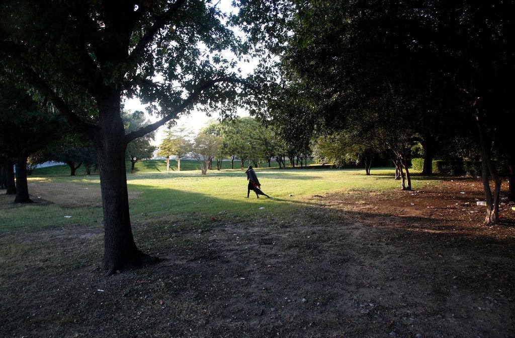 A homeless man drags a blanket in Martyrs Park in Dallas on Thursday, Oct. 5, 2017. The city has been clearing out more homeless encampments from city parks this year after the unsheltered moved to parks in greater numbers during the height of the coronavirus pandemic. 