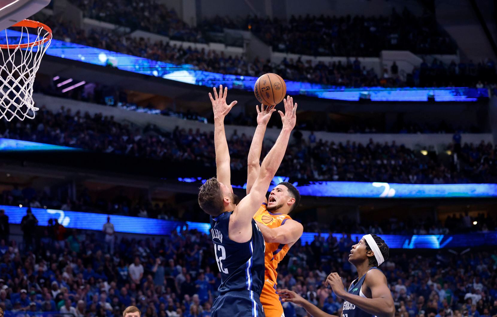 Phoenix Suns guard Devin Booker (1) puts up a jump shot over Dallas Mavericks forward Maxi...
