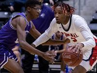 Justin F. Kimball High School Arterio Morris (2) dribbles the ball past Sunset High School Alex Sterling (24) during the game at Ellis Davis Field House in Dallas, Friday, January 14, 2022. Justin F. Kimball High School won the game against Sunset High School 89-32.