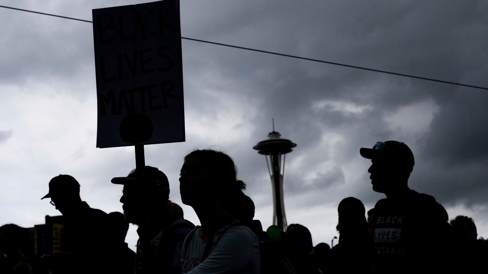 People attend a rally Sunday, Aug. 13, 2017, in Seattle. Hundreds of demonstrators and...