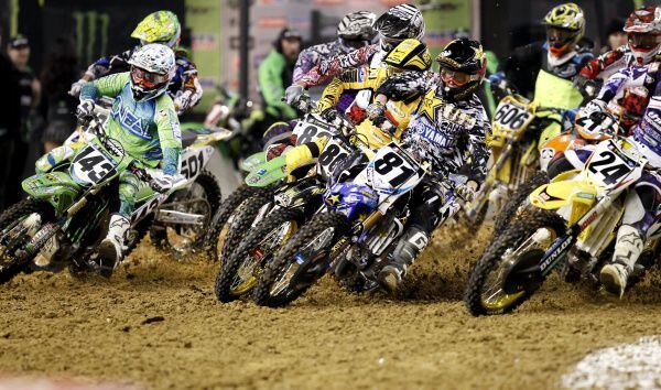 Supercross racers bunch up as they make the first turn during a Monster Energy AMA...