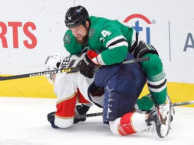 Dallas Stars left wing Jamie Benn (14) keeps Florida Panthers defenseman MacKenzie Weegar (52) from getting up in the first period at the American Airlines Center in Dallas, Tuesday, April 13, 2021.