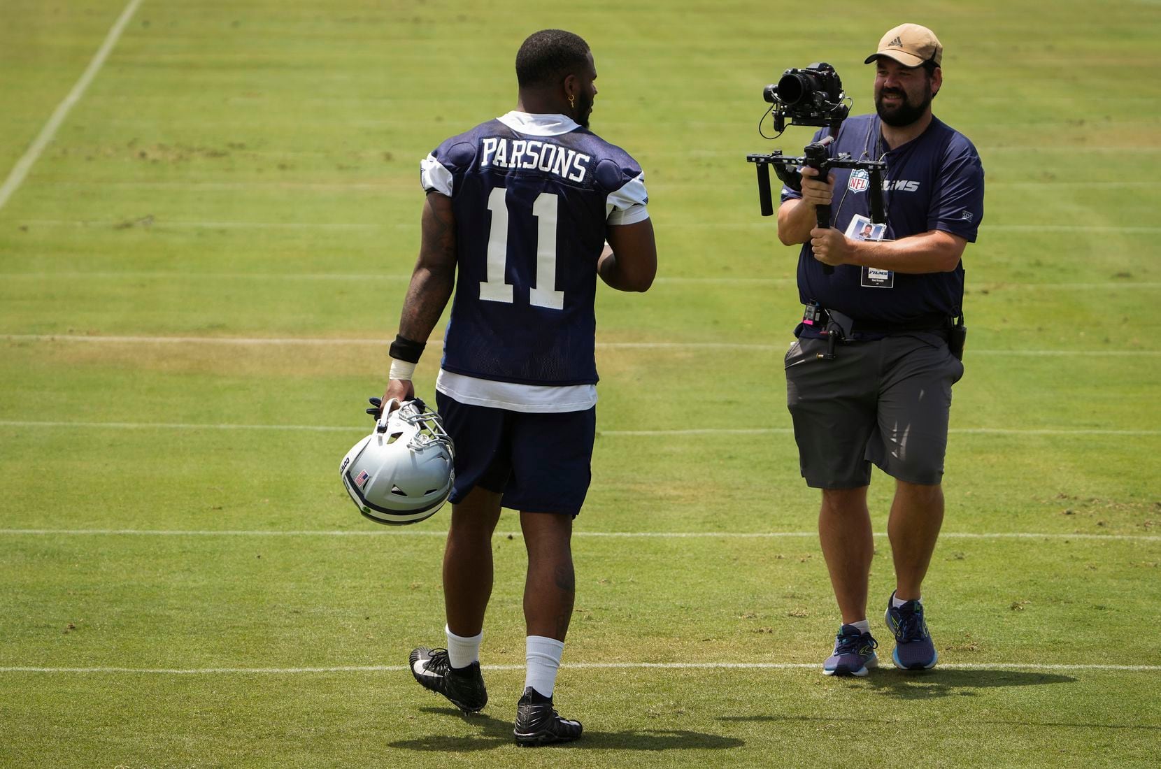 A camera operator for HBO’s Hard Knocks walks captures Dallas Cowboys linebacker Micah...