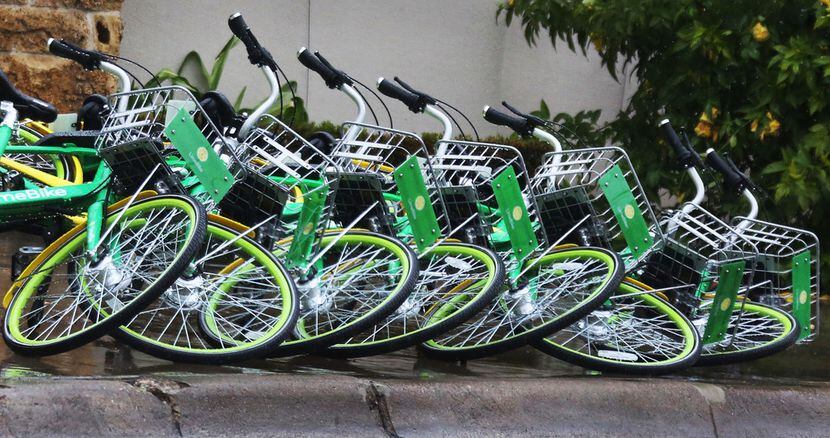 LimeBike rental bikes lie knocked over in a line along Young Street in downtown Dallas the...