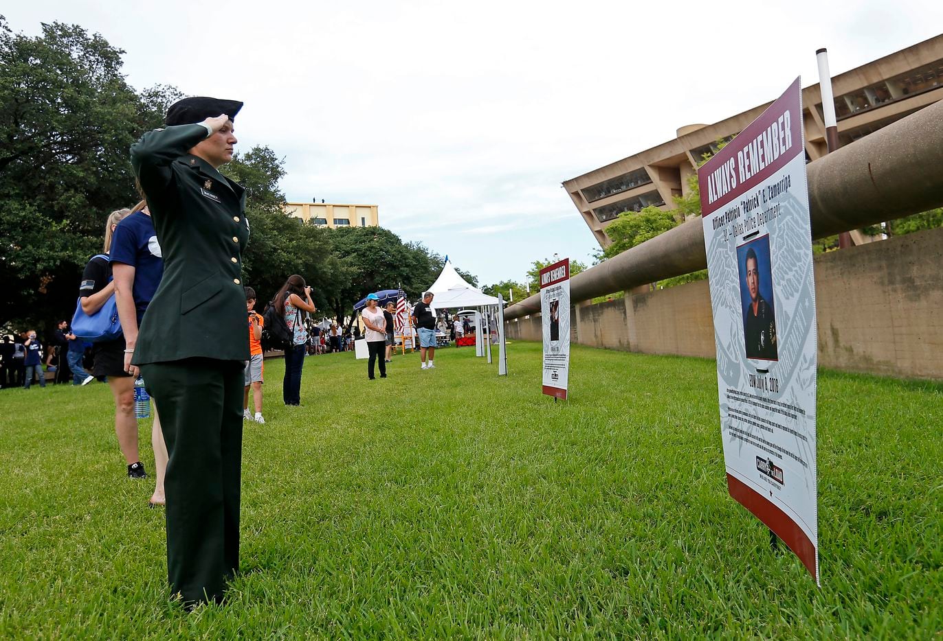 Military veteran Valorie McKinney salutes as she visits the memorials of five fallen police...