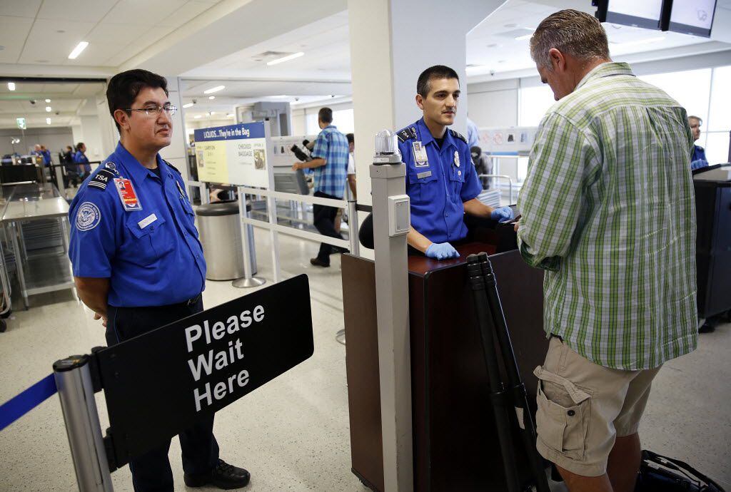 TSA agents check passengers boarding passes in Terminal A of Dallas-Fort Worth International...