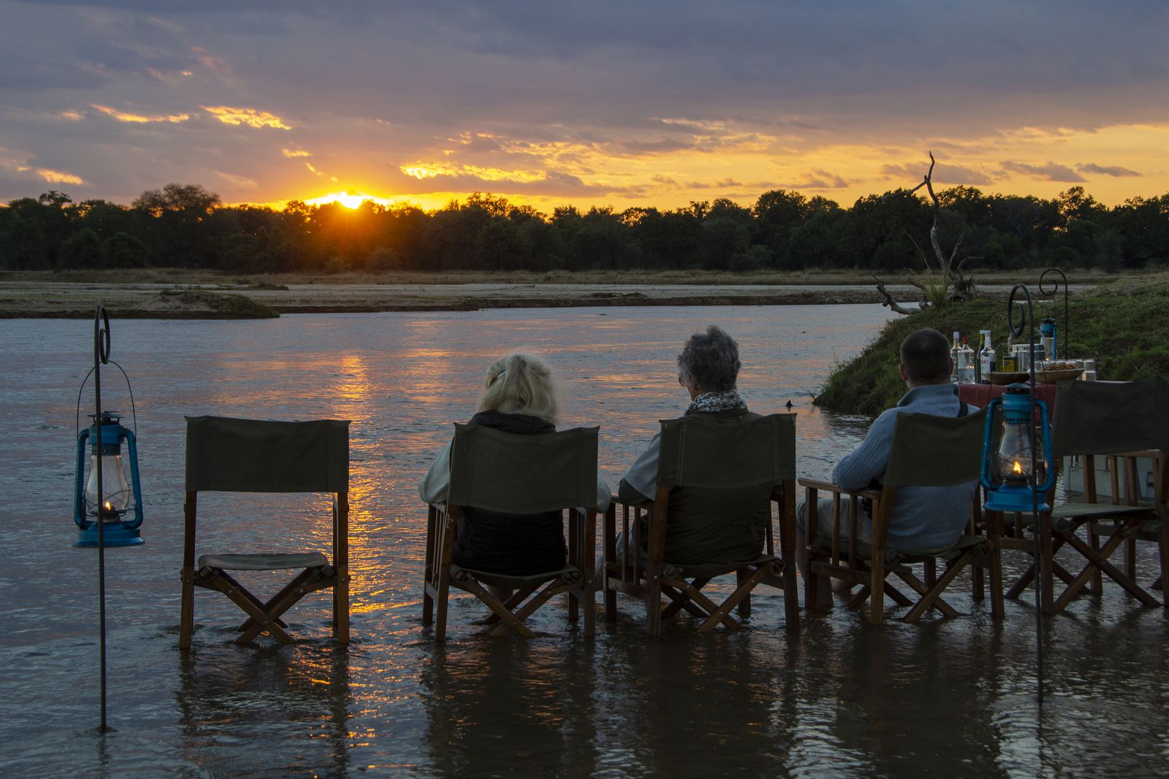 Visitors watch the sunset over the Kapamba River in Zambia's South Luangwa National Park.