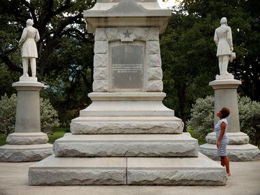 Victoria Miller of Dallas reads an inscription on the Confederate War Memorial in Pioneer...