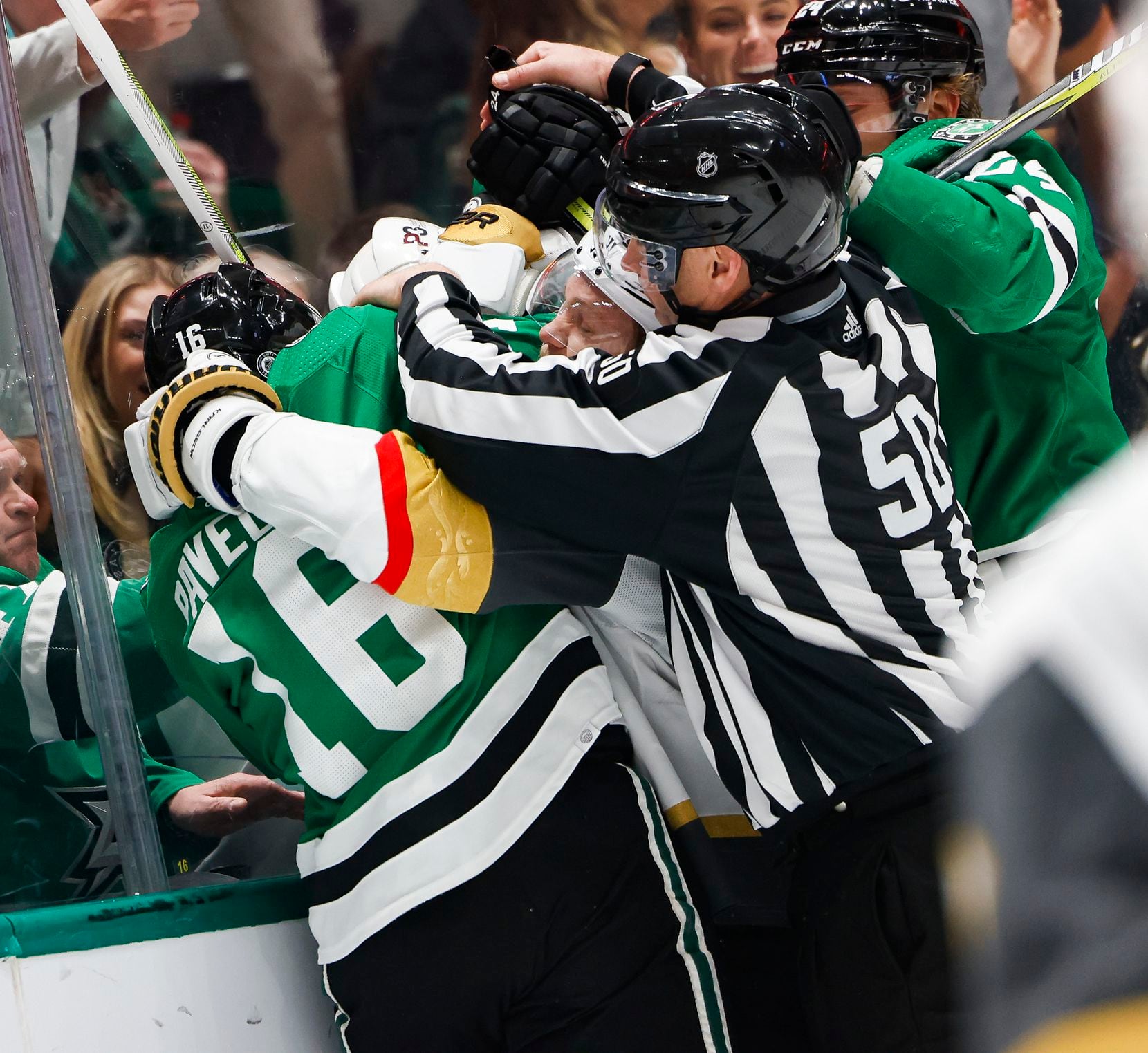 A referee attempts to pull players off during a fight in the third period of a game, on...