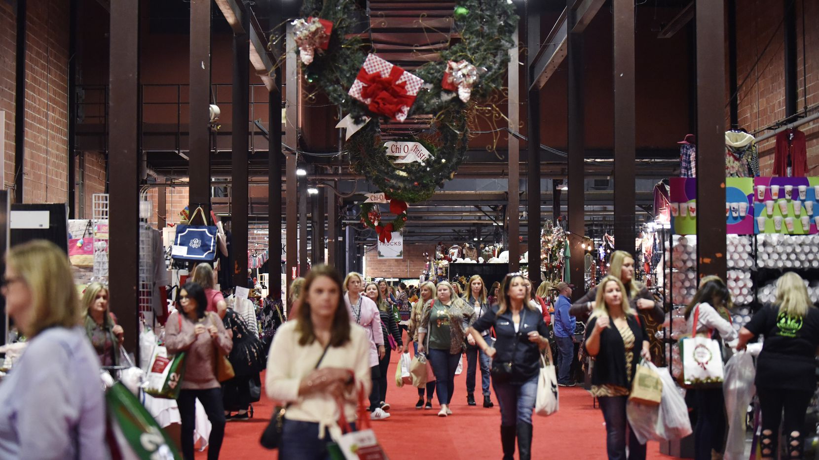 Shoppers walked the main market floor Thursday evening during the Chi Omega Christmas Market at Fair Park in Dallas. The market runs through Saturday.