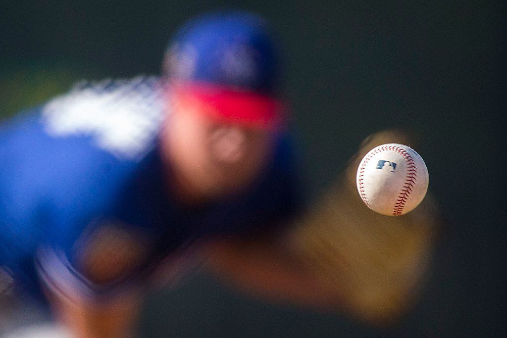 Texas Rangers pitcher Adrian Sampson pitches during a spring training workout at the team's...