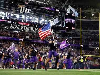 TCU Horned Frogs tight end Jared Wiley (19) carries the U.S.flag as he leads his team onto...