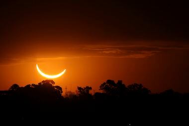 FILE - The moon passes in front of the setting sun during a total solar eclipse in Buenos...