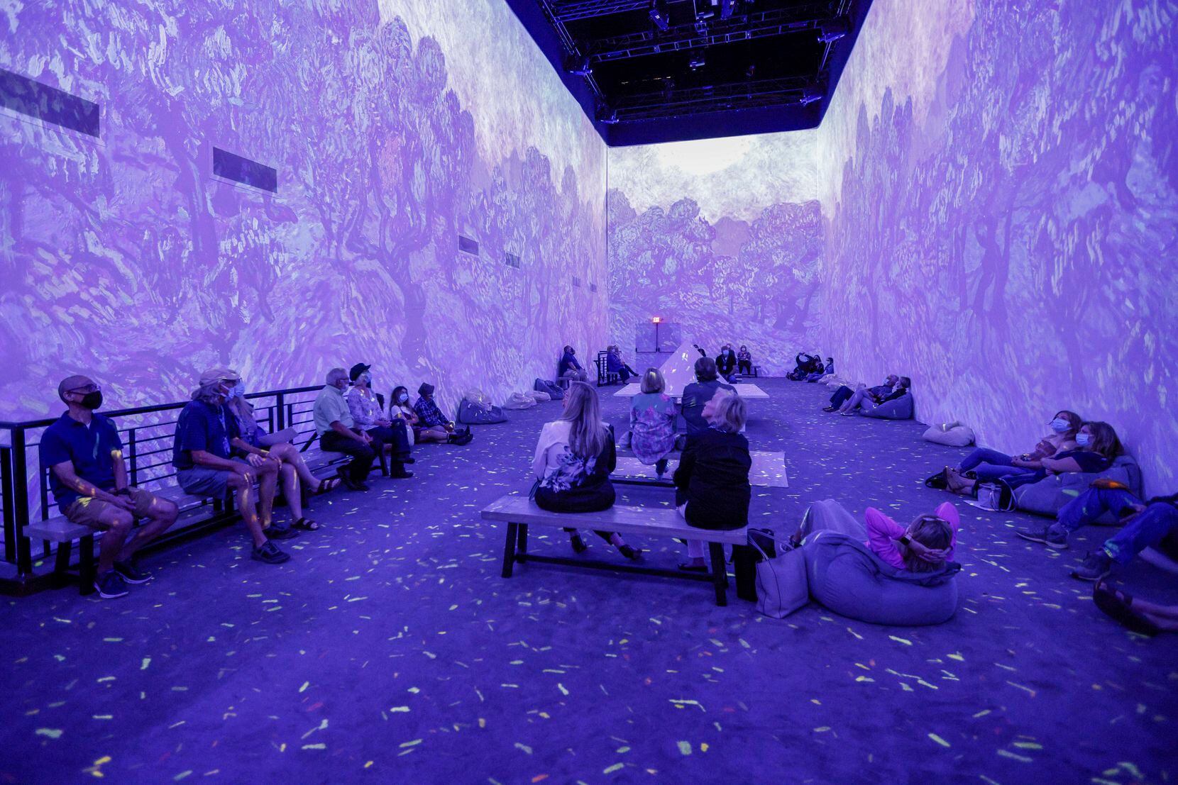 Visitors watch projections of work by Vincent Van Gogh at "Van Gogh: The Immersive...