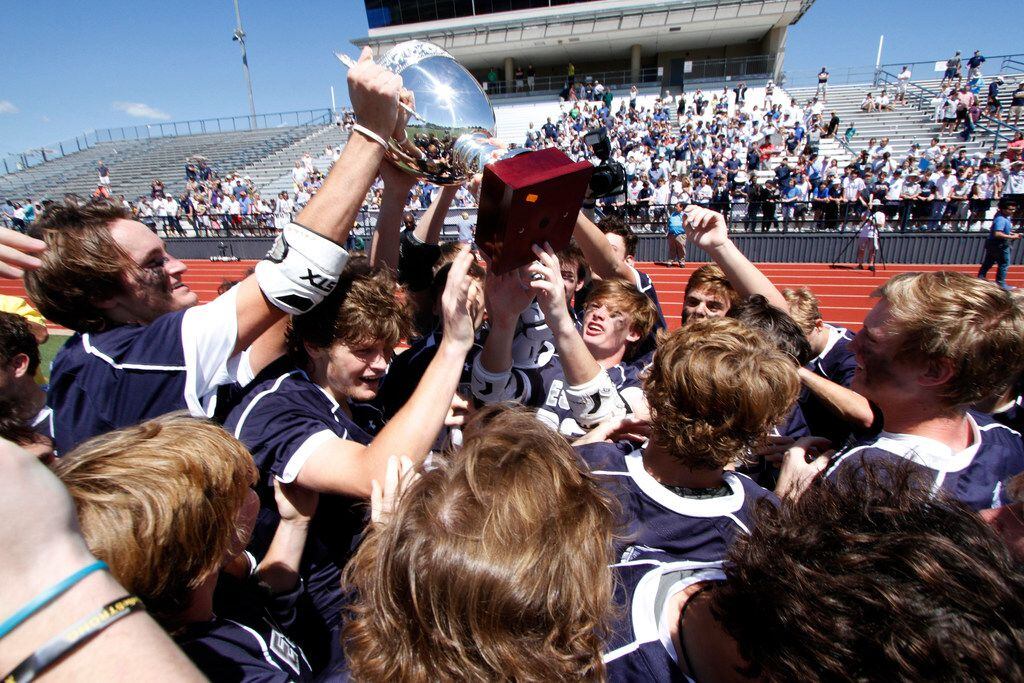 Episcopal School of Dallas lacrosse players celebrate as they raise the championship trophy...