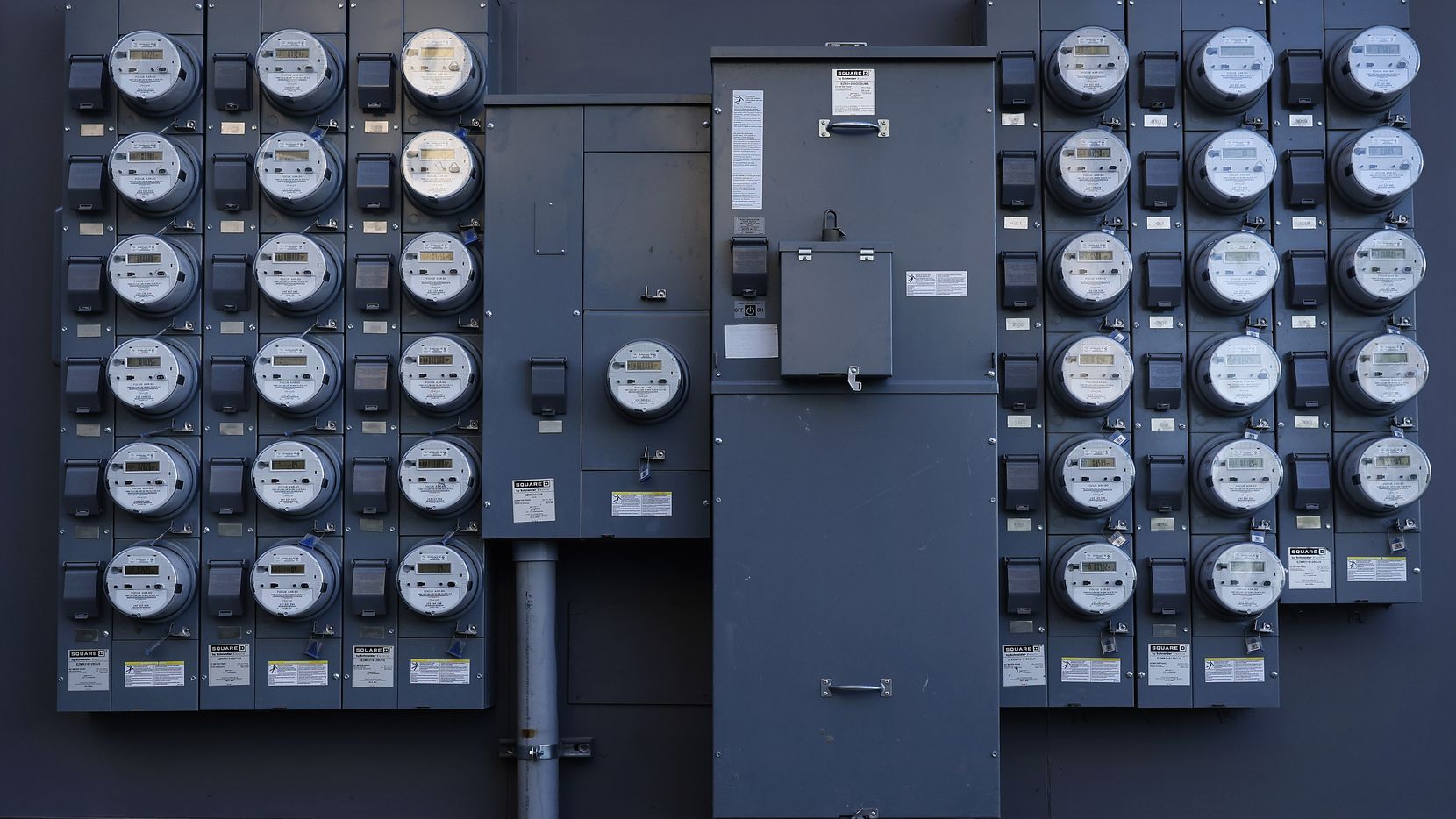Rows of apartment electrical meters line the wall near downtown Dallas. While gasoline...