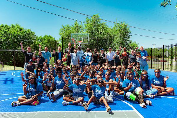 Mavs forward Max Kleber with kids on the new court at Frazier Revitalization donated by The...