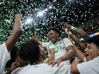 North Texas' Tylor Perry (5) holds up the trophy while celebrating with teammates after...