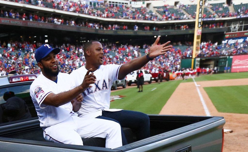 Texas Rangers shortstop Elvis Andrus (1) and former Rangers player Adrian Beltre ride in a...