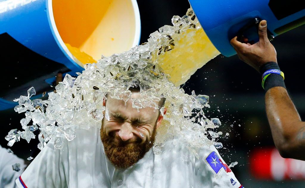 Texas Rangers catcher Jonathan Lucroy (25) is doused with sports drink by teammates Elvis...