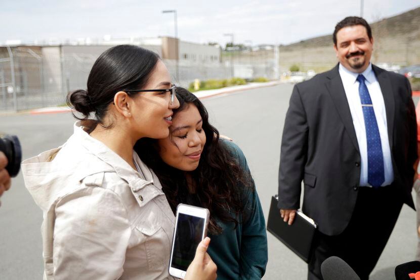 Chantal Estrada, al centro, hija de Perla Morales Luna, abraza a la amiga de la familia,...