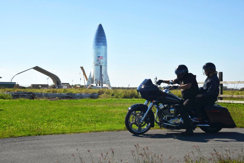 A motorcyclist rides off in his Harley Davidson near the SpaceX prototype Starship hopper at South Texas' Boca Chica Beach.