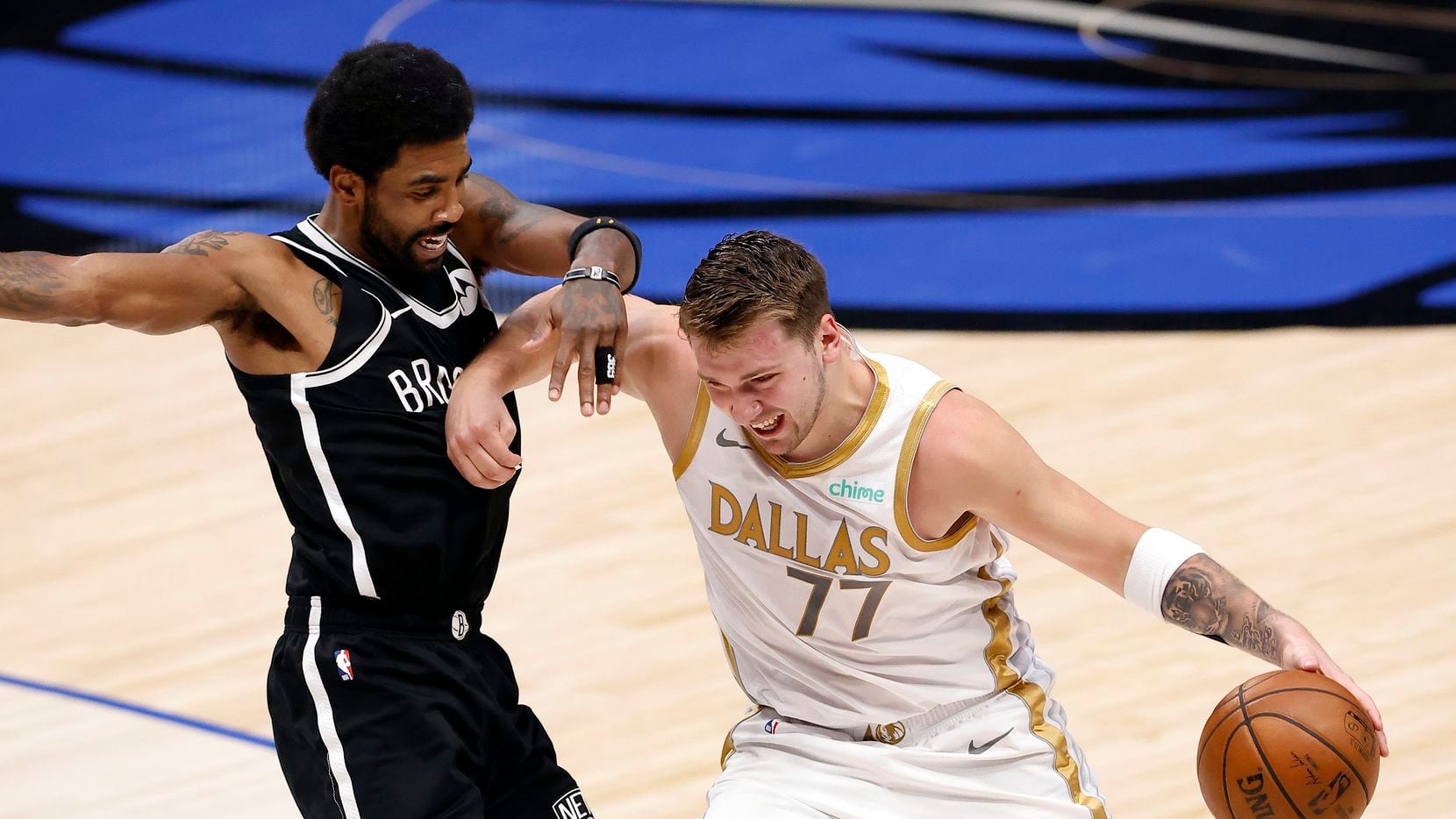 Dallas Mavericks guard Luka Doncic (77) forces his way past Brooklyn Nets guard Kyrie Irving...