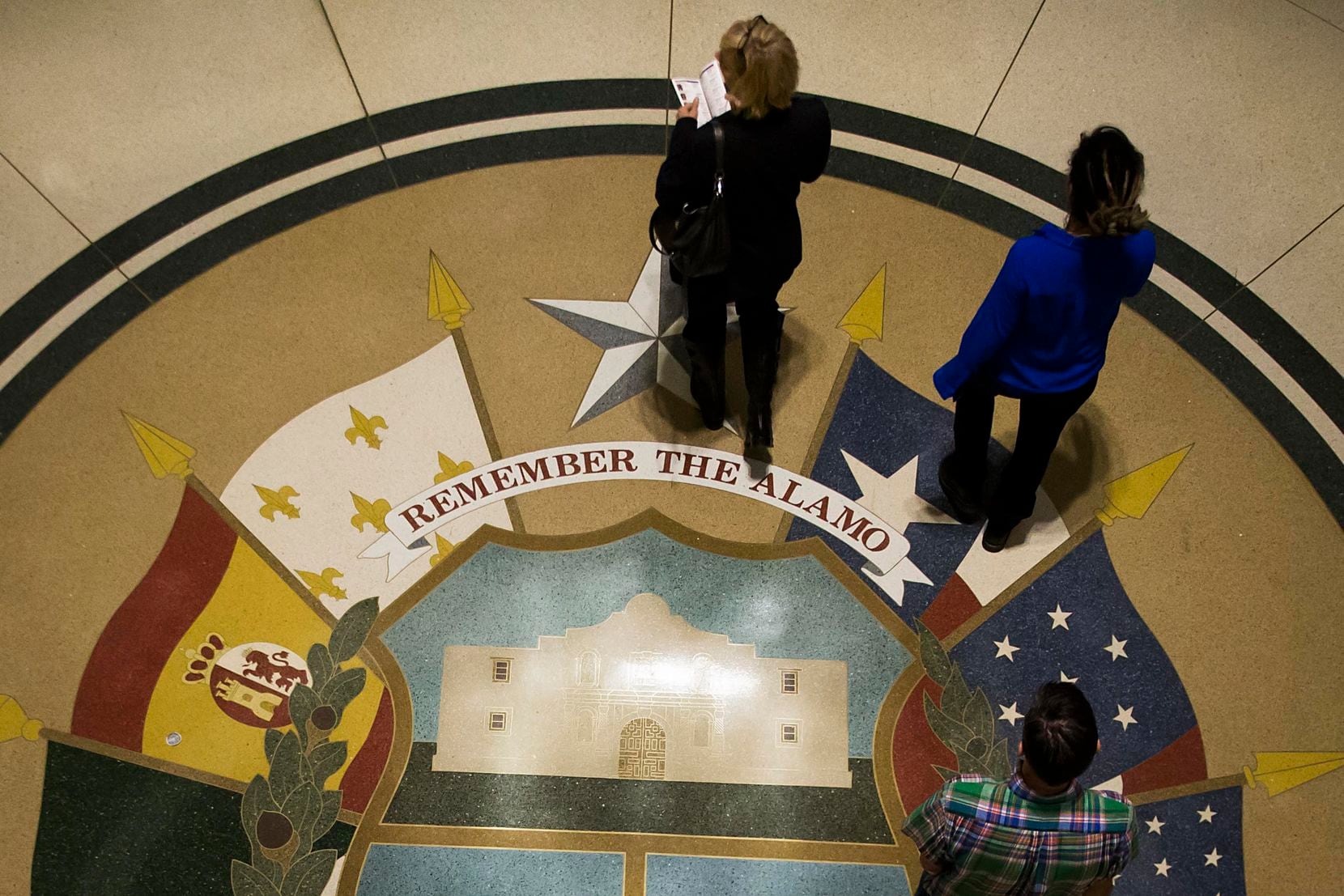 Christy Zartler (top) consults a legislative directory as she walks the halls of the Texas...