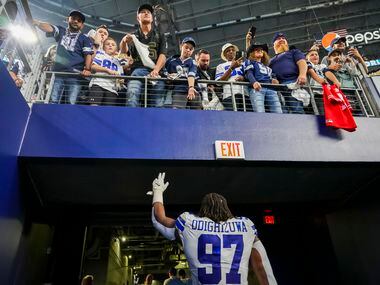 Dallas Cowboys defensive tackle Osa Odighizuwa waves to fans as he leaves the field...