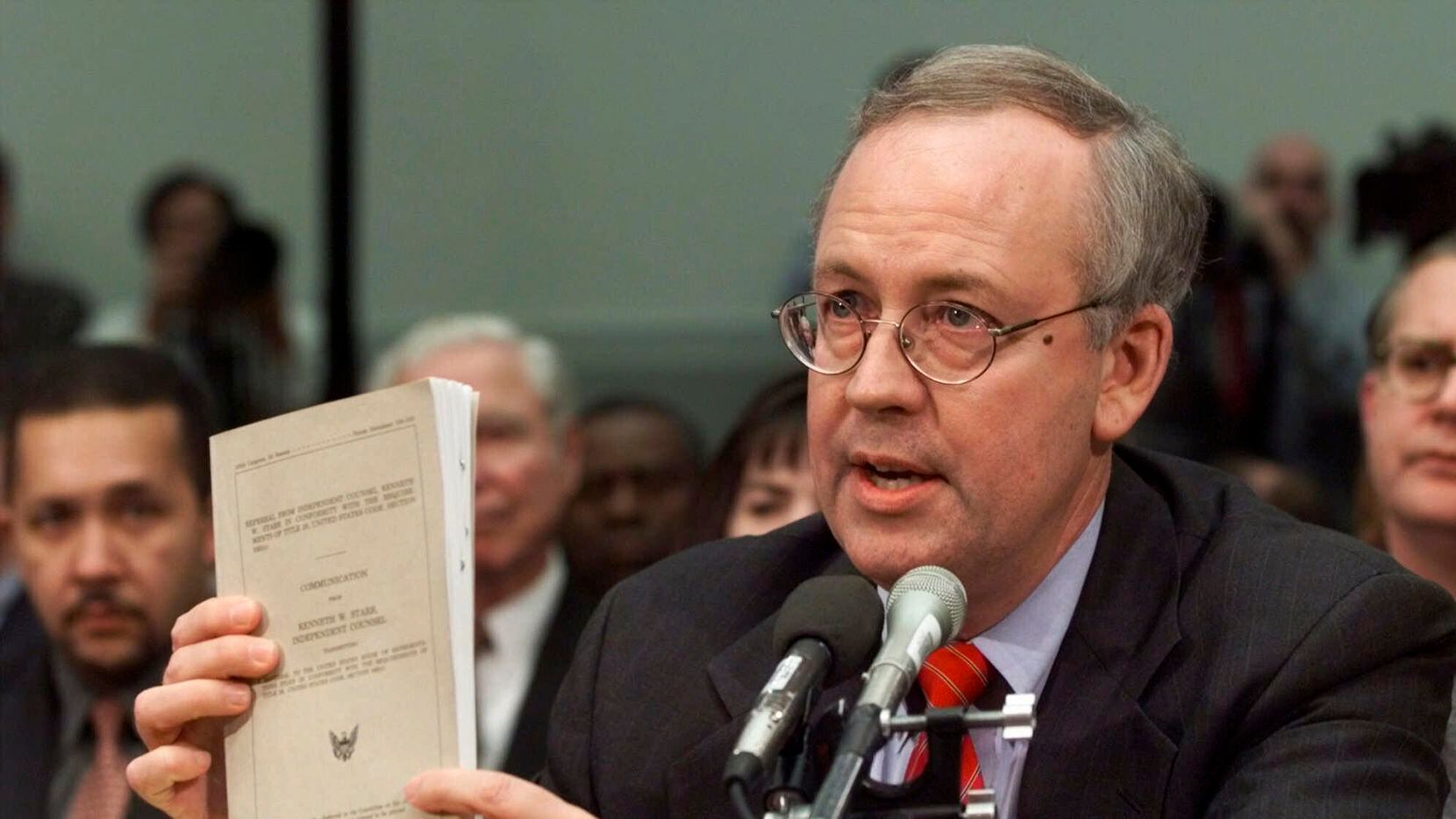 FILE - Independent Counsel Kenneth Starr holds a copy of his report while testifying on...