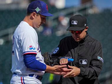Texas Rangers pitcher Tai Tiedemann has his hands checked by an umpire during the sixth...