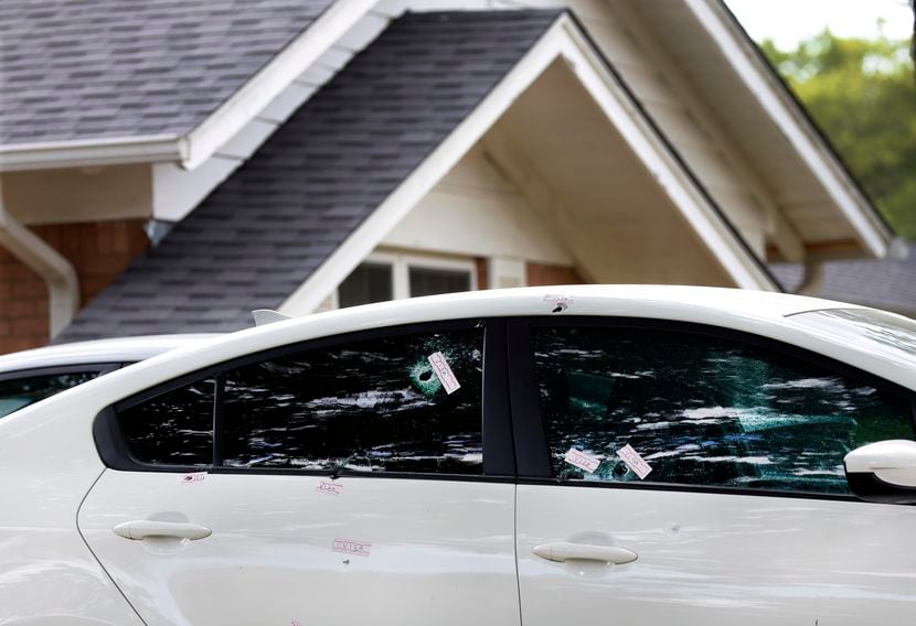 Bullet holes in the side windows of a KIA car are pictured in the driveway to the initial...