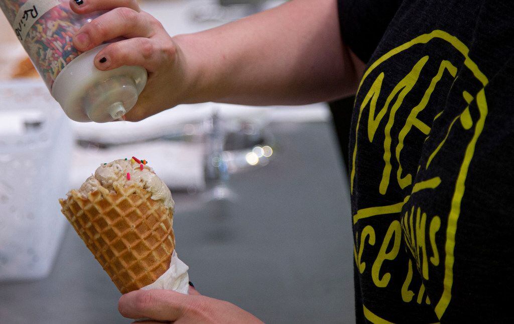 Paige Sell prepares an ice cream cone of Cup of Texas, a coffee flavored ice cream, at Melt...
