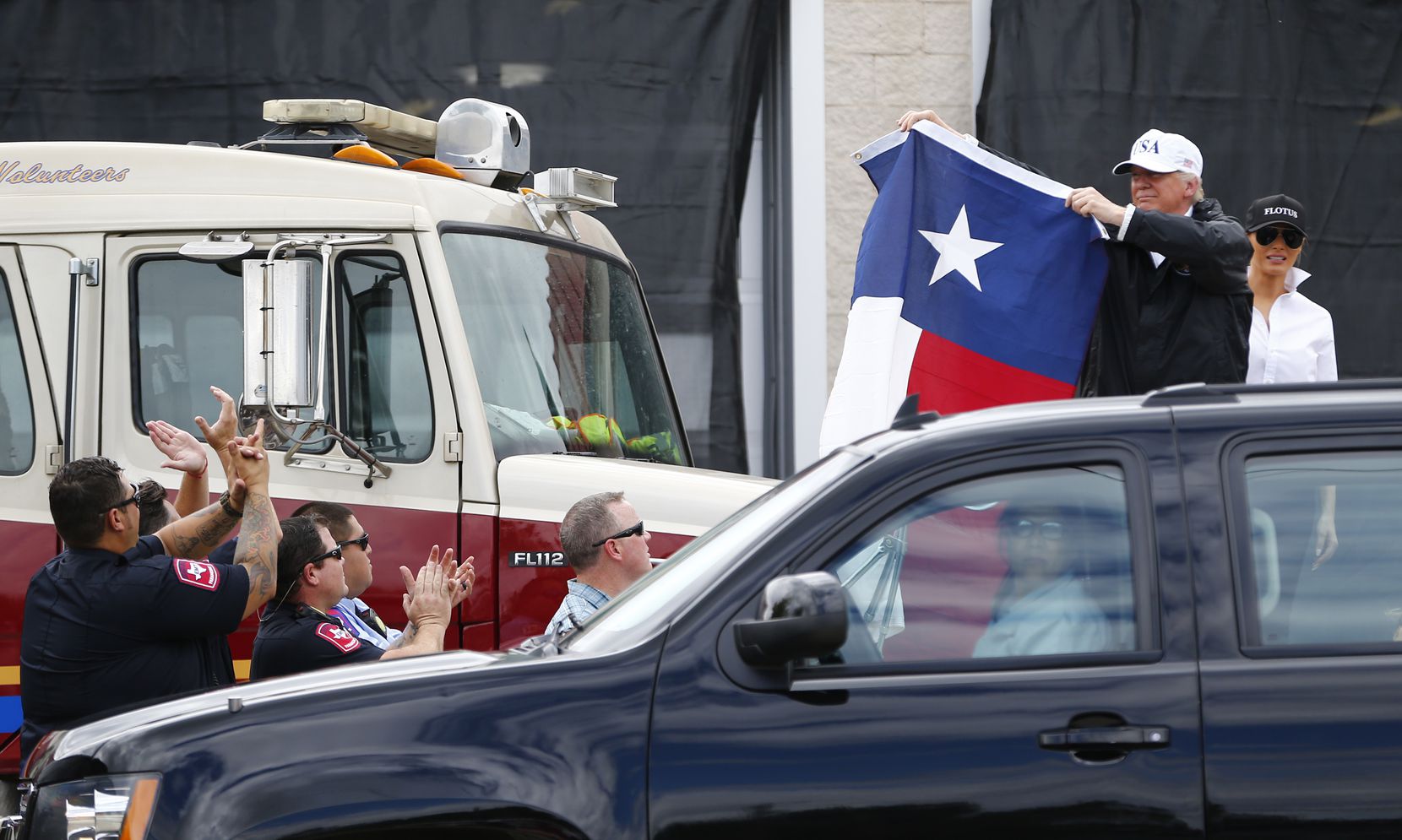 President Donald Trump holds up a Texas flag after attending a briefing from dederal, state...